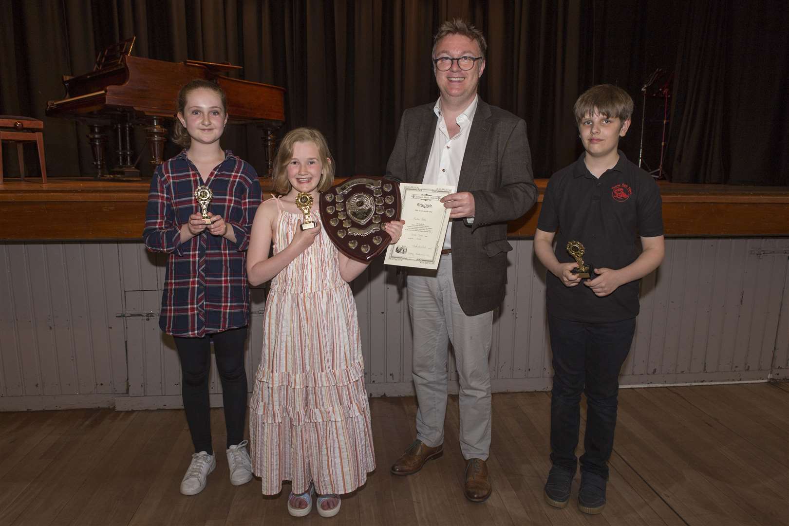 Martha Potts, of Mount Pleasant, won the Henry Rosie Memorial Shield in the vocal solo final on Friday night. She received the trophy from adjudicator Richard Yarr, alongside other finalists Ola Omand and Charles Fryett, both Thurso High School. Picture: Robert MacDonald / Northern Studios