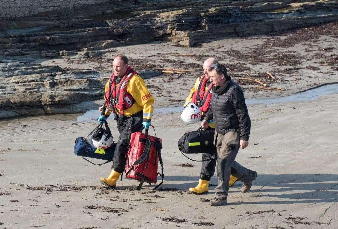 Two RNLI crew members being shown to the casualty on Friday by lifeboat operations manager Scott Youngson. Picture: Thurso RNLI
