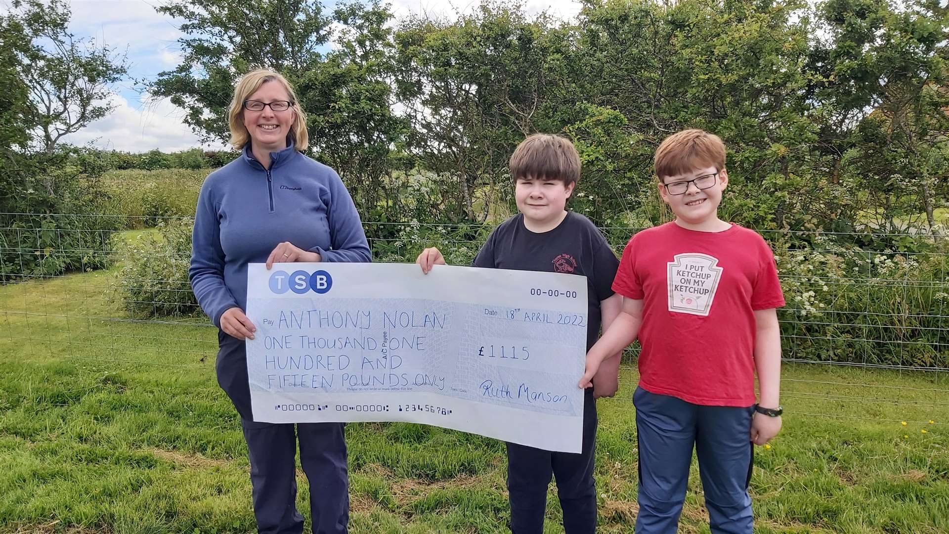 Ruth Manson presenting the cheque for Anthony Nolan to Euan and Arran Macleod.