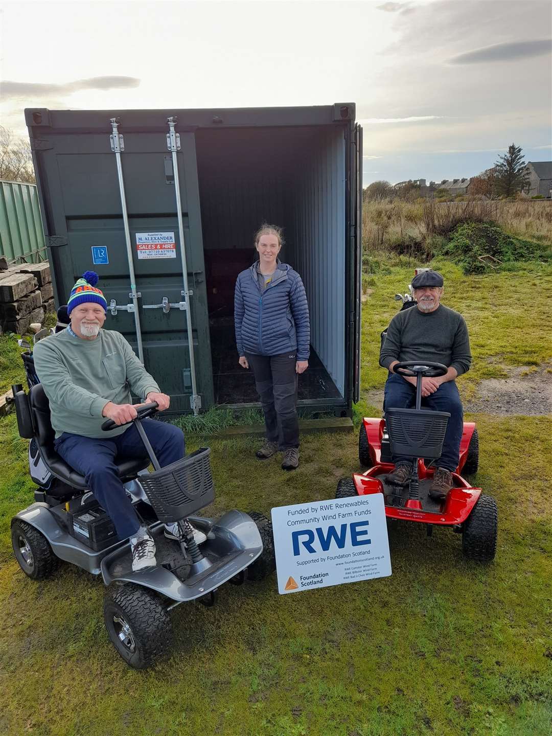 Eilidh Coll of Foundation Scotland (centre) in front of the container with Dave Wilson (left) and Malcolm Sutherland on the new buggies.