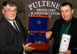 Malcolm Waring, of Pulteney Distillery, presents the Old Pulteney Maritime Achievement Award to Billy Farquhar.