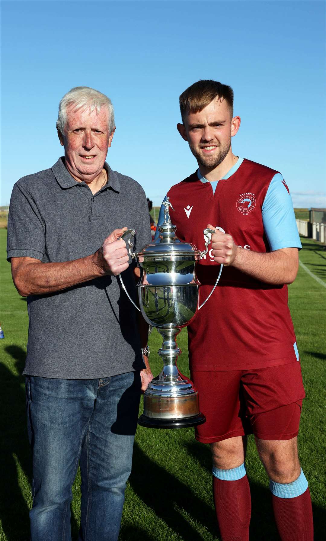 Caithness AFA president Murray Coghill presents the league trophy to Pentland United captain Luke Manson. Picture: James Gunn