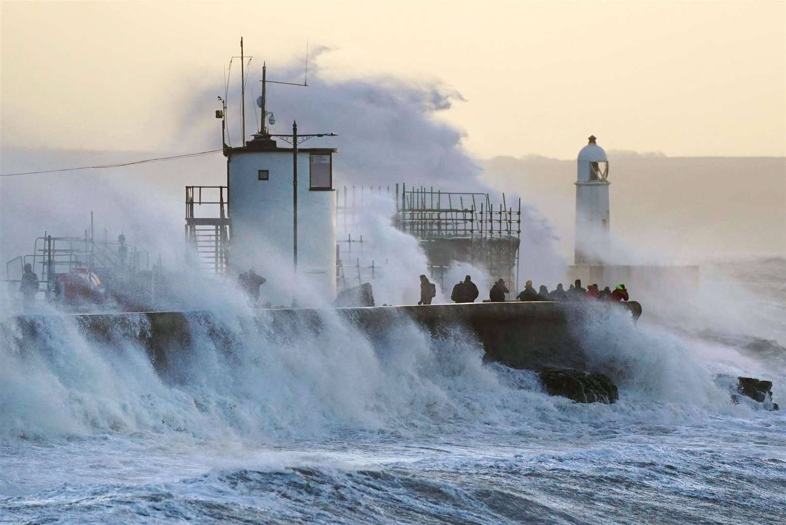 Waves crash against the sea wall and Porthcawl Lighthouse, Bridgend, as Storm Eunice hits the south coast (Jacob King/PA)