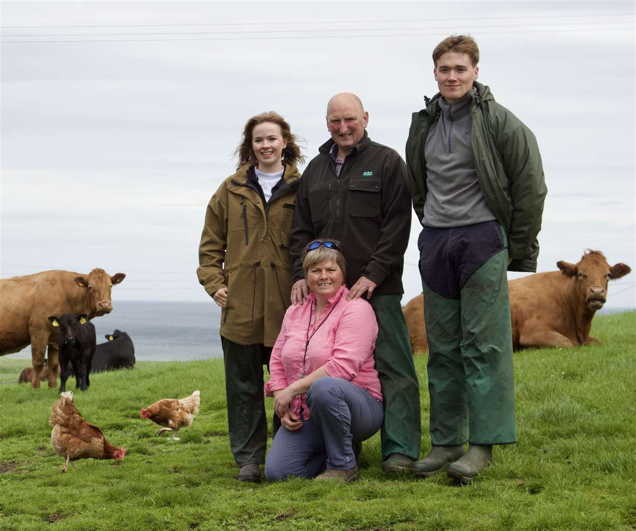 The Armadale Farm team with the cattle in the background, along with a couple of the free-range hens. Joyce can be seen kneeling in the front, with husband Ian behind, flanked by Frances and Mure. Picture: Caroline Jones