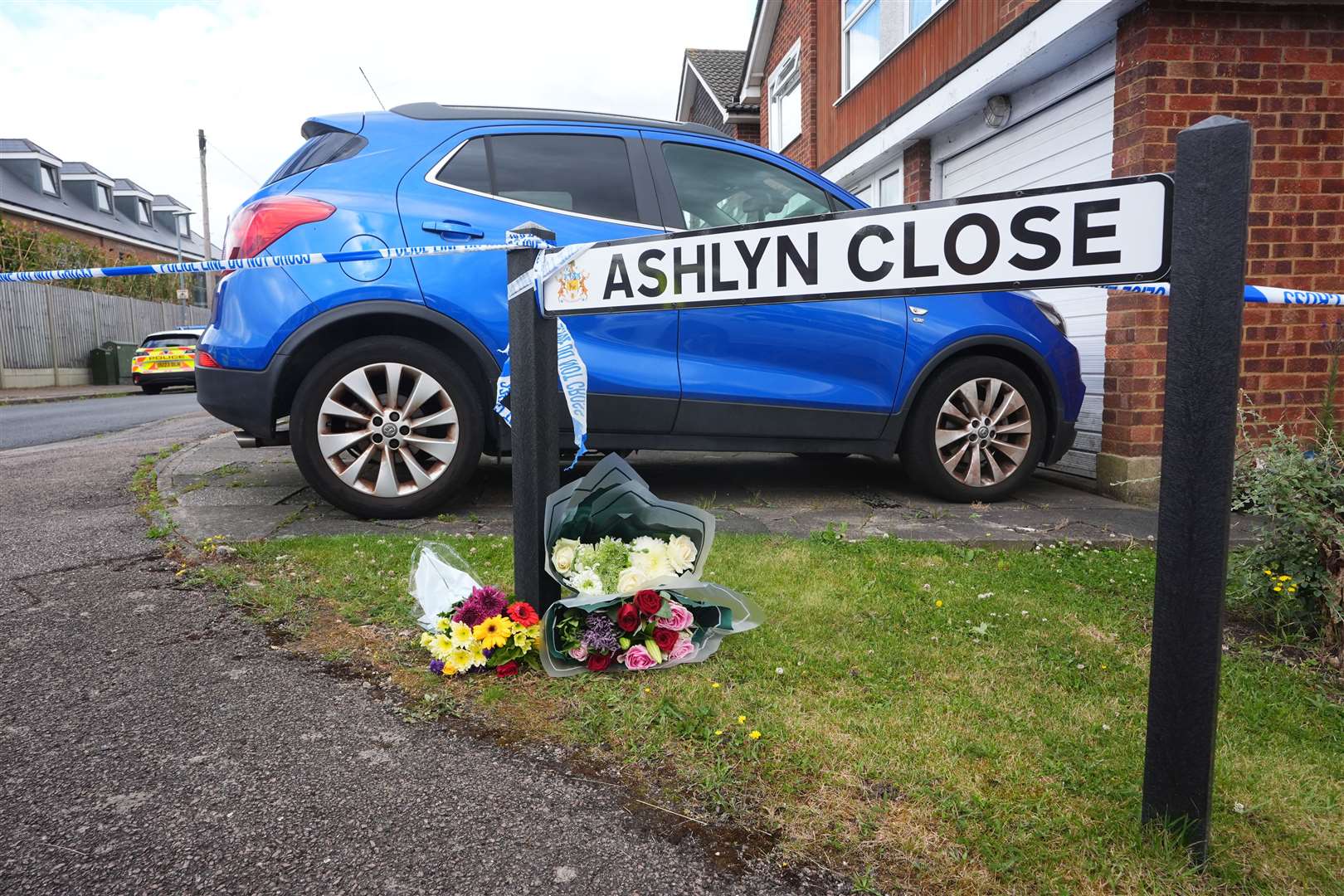 Flowers left near the scene in Ashlyn Close, Bushey, where the wife and two daughters of a BBC sports commentator have been killed in a crossbow attack (James Manning/PA)