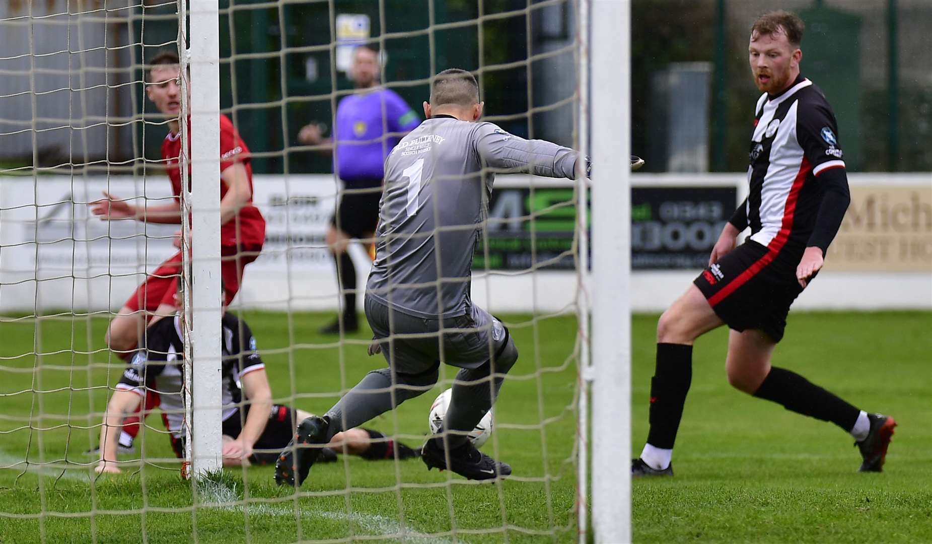 Academy keeper Graeme Williamson blocks a shot from Lossiemouth's Ross Morrison. Picture: Mel Roger