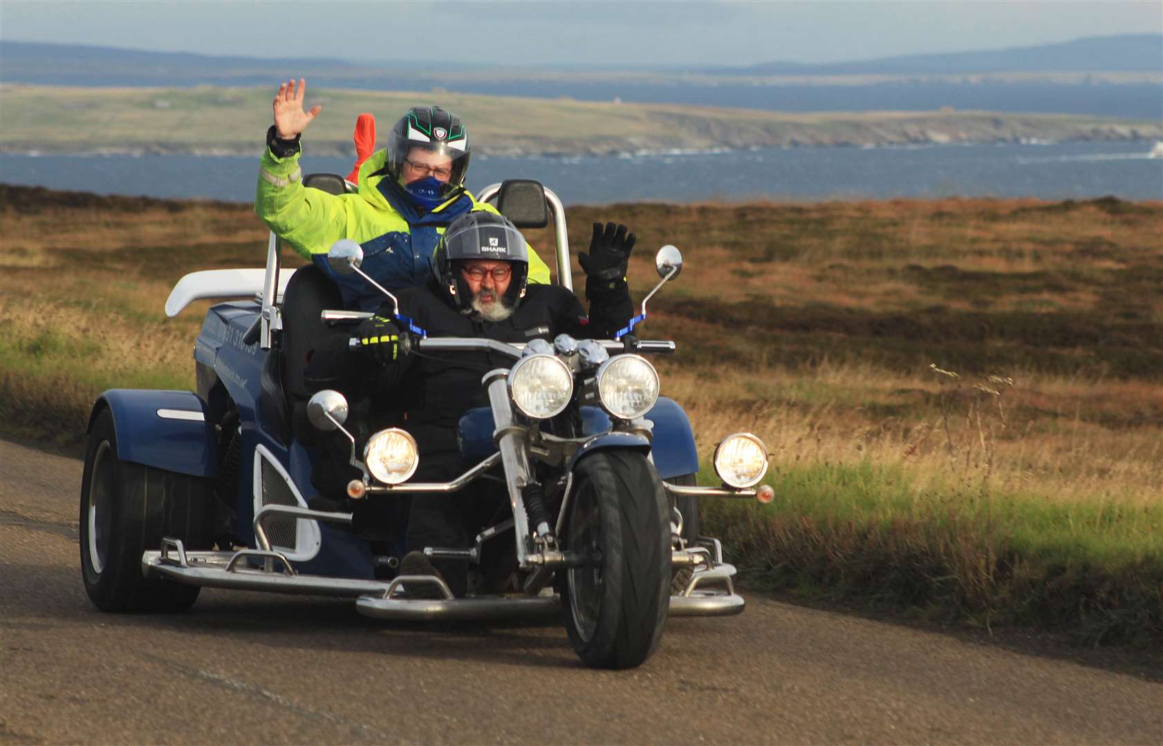 John Foster and son Jacob give a wave as they head out of John O'Groats on the trike. Picture: Alan Hendry