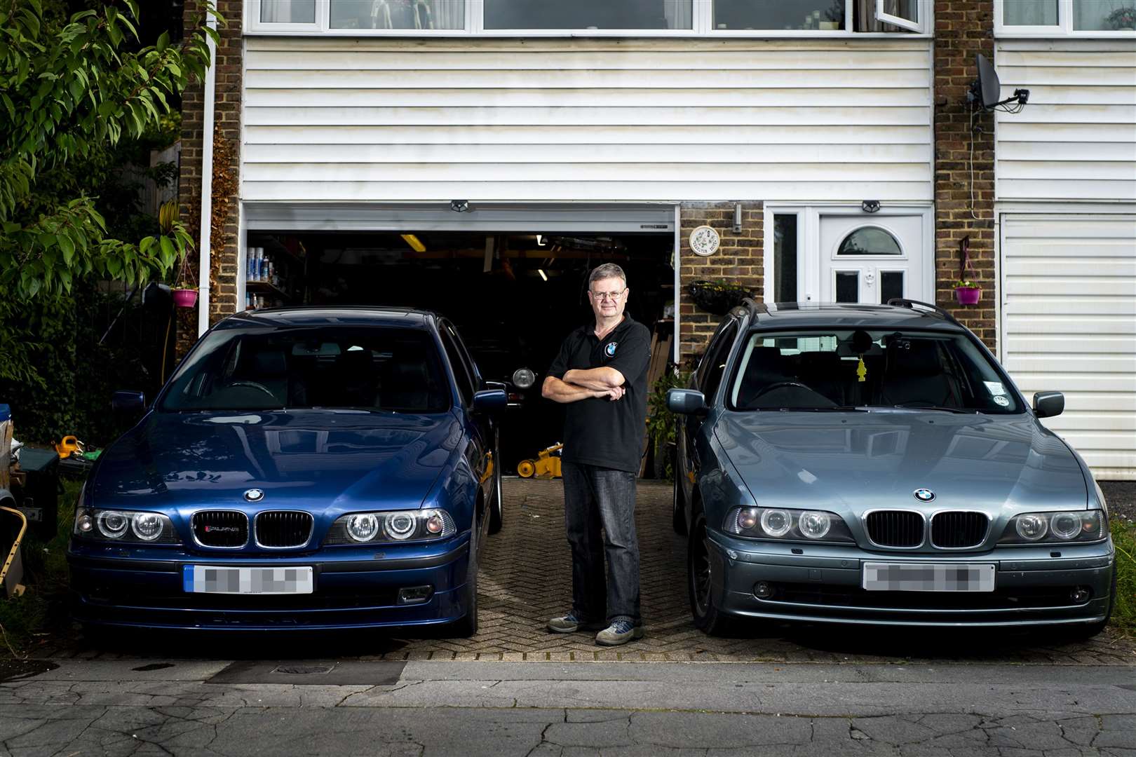 Paul Robins with his (left) Mid 2000 B10 3.3 litre which is Ulez compliant and (right) Mid 2000 BMW 530i Touring which is not (Jordan Pettitt/PA)