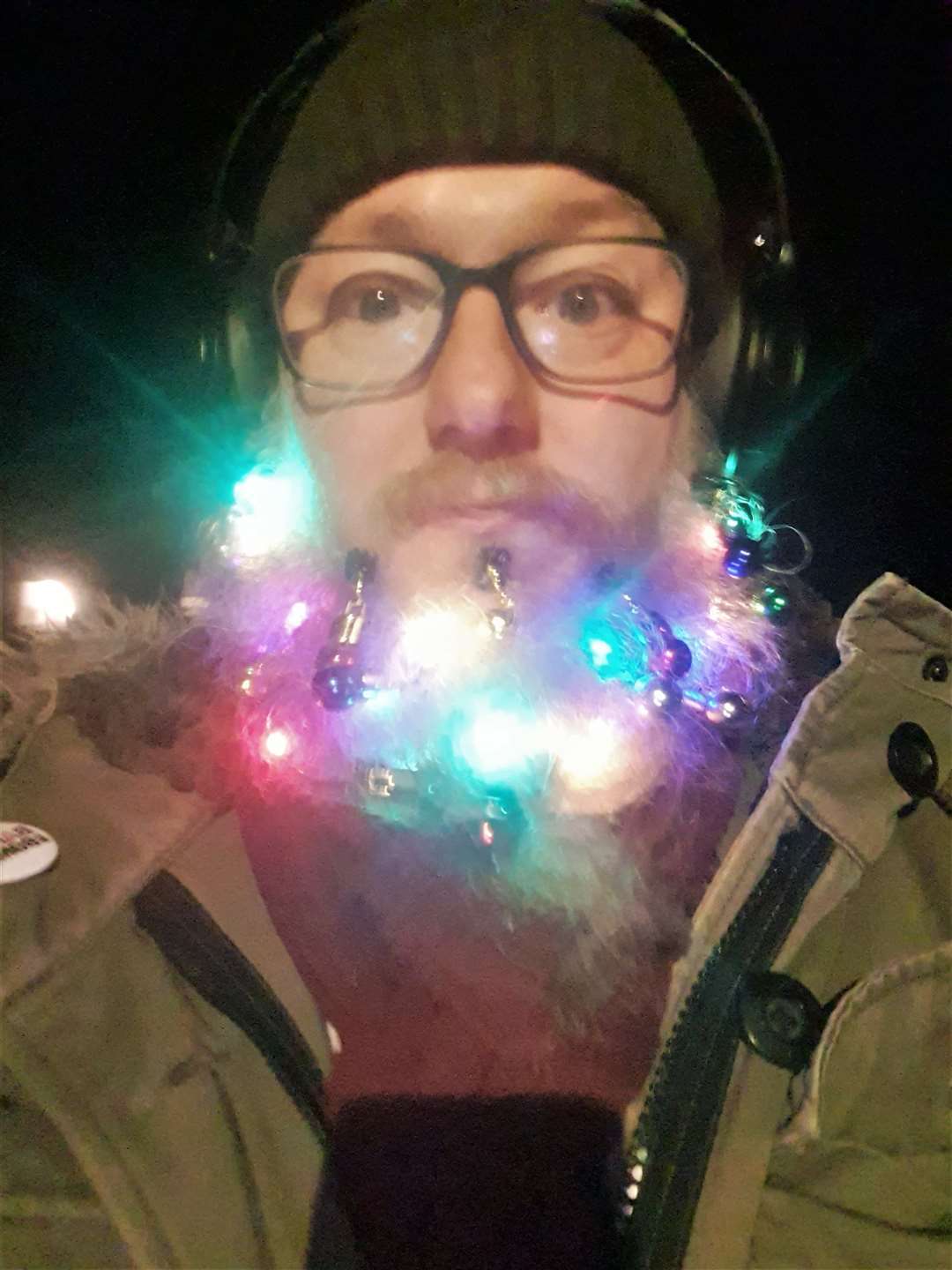 Ryan hangs Christmas lights from his beard.