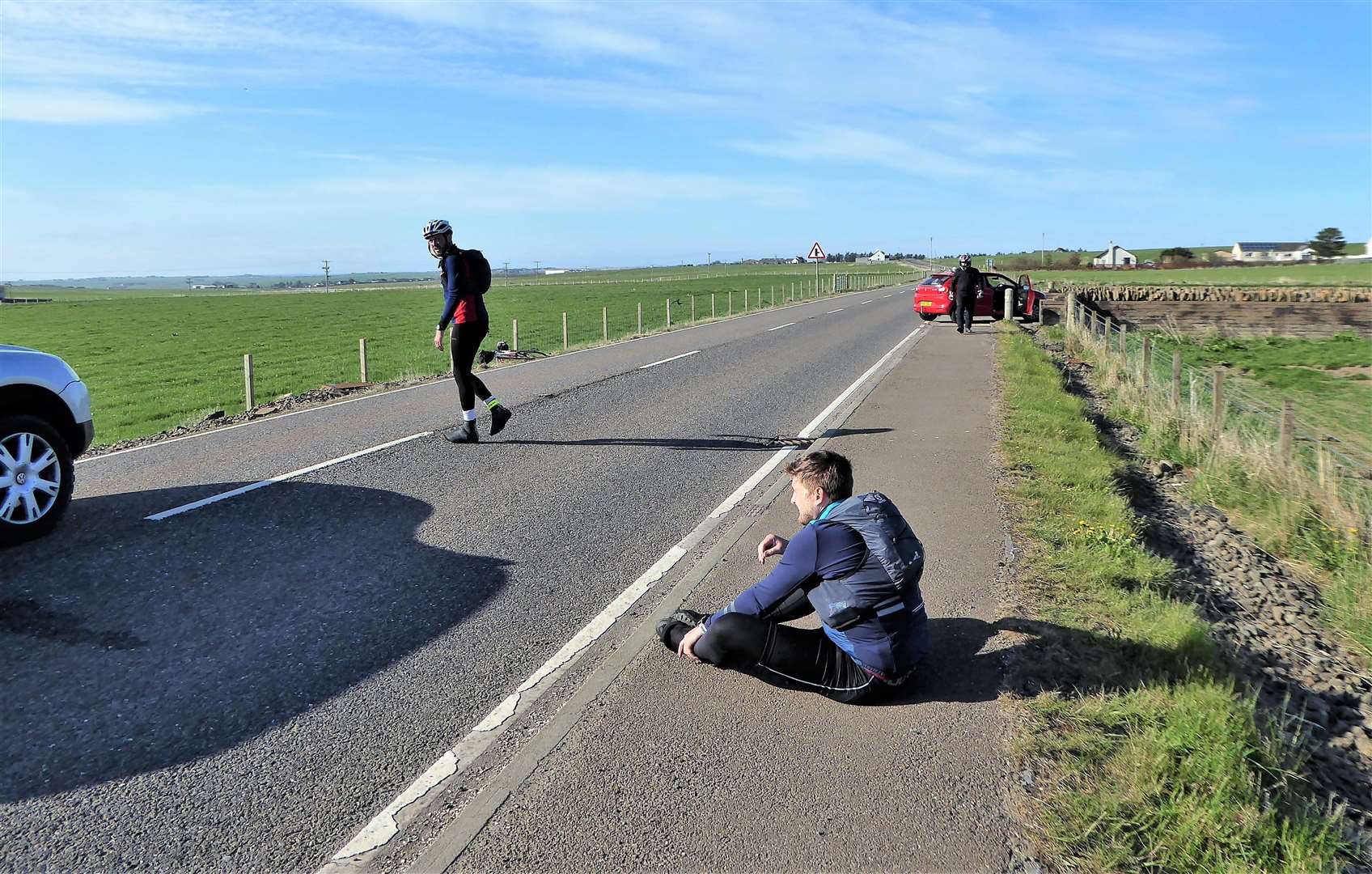 The injured cyclist sits on the pavement just after the incident on the A99 just south of Wick.