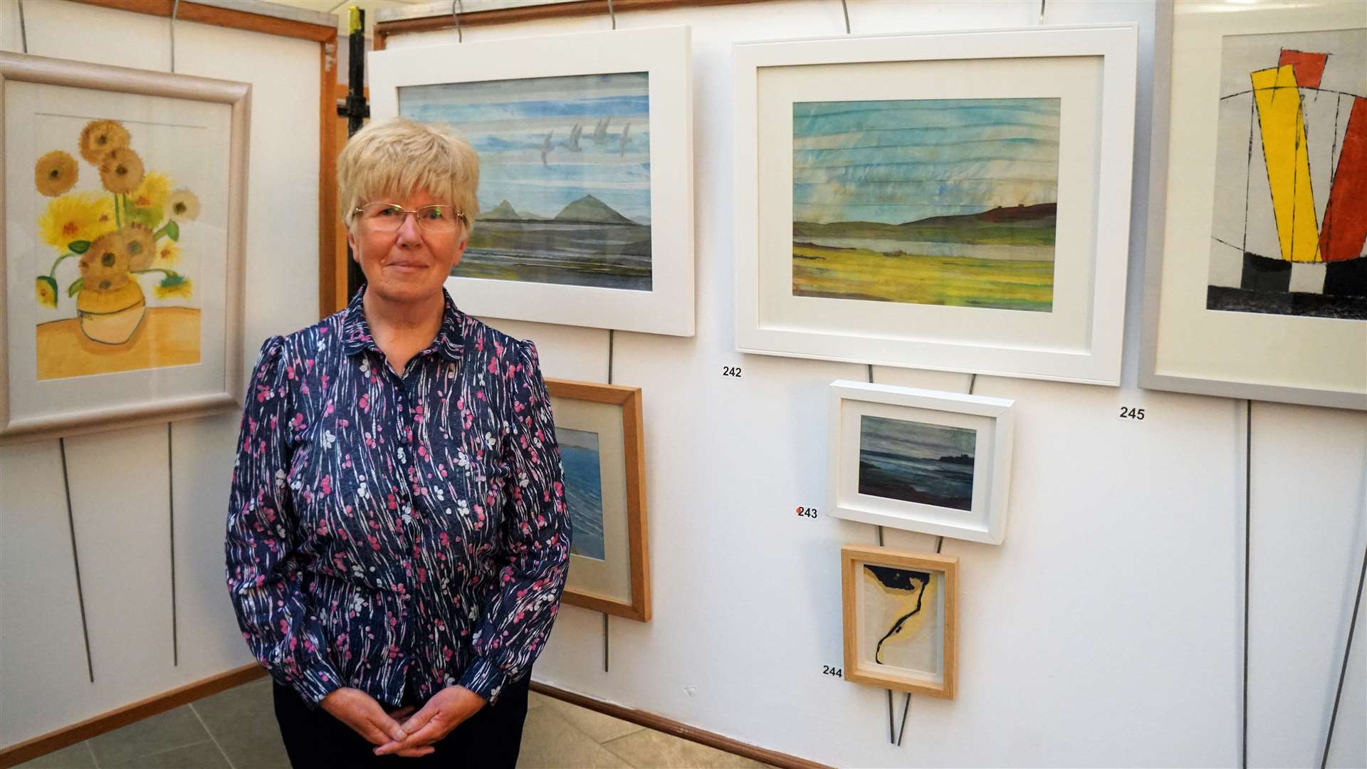 Valerie Barker at the Society of Caithness Artists exhibition in Thurso next to her own artworks. Valerie did a statistical analysis of how artists valued their works based on gender. Picture: DGS