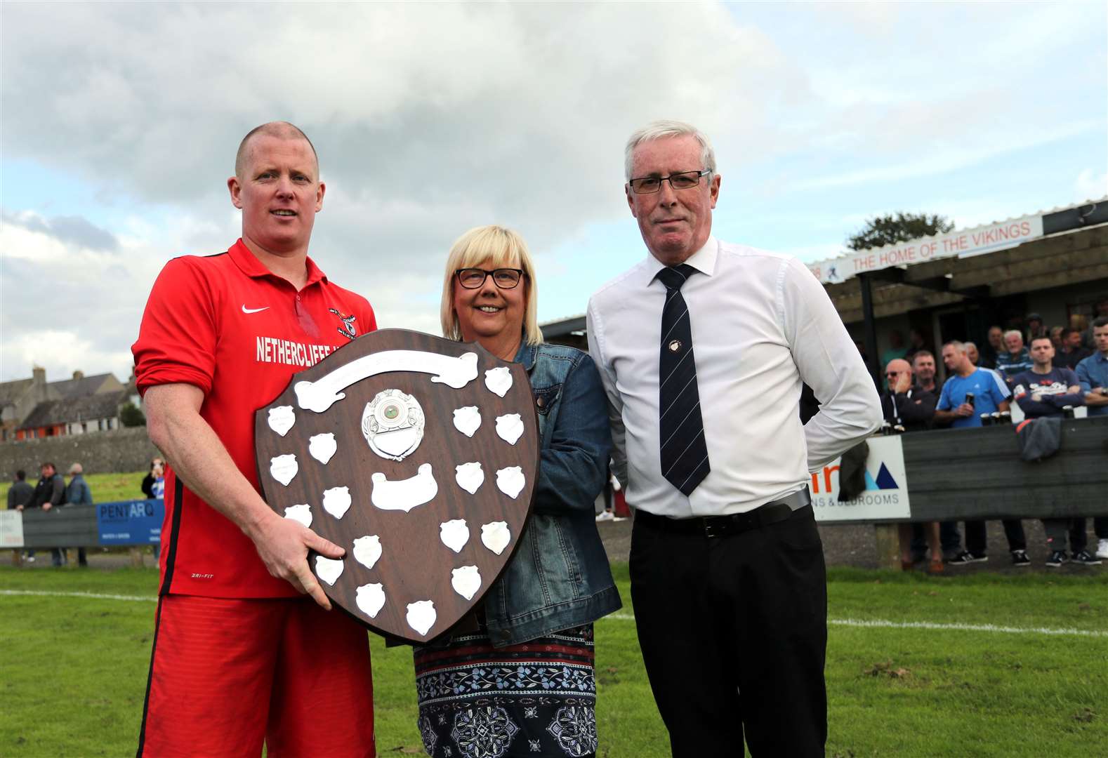 Alan Sinclair of Wick Groats receives the David Allan Shield in 2019 from Linda Moran, watched by Caithness AFA president Murray Coghill. Picture: James Gunn