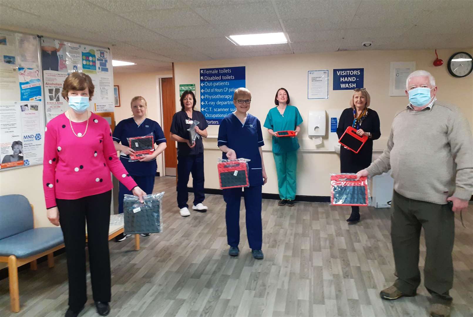 Barbara Nicol from the League of Friends of Caithness General Hospital and Bill Fernie of Caithness Health Action Team presenting tablets to Pam Garbe, rural general hospital manager for the north area, and representative staff from each ward.