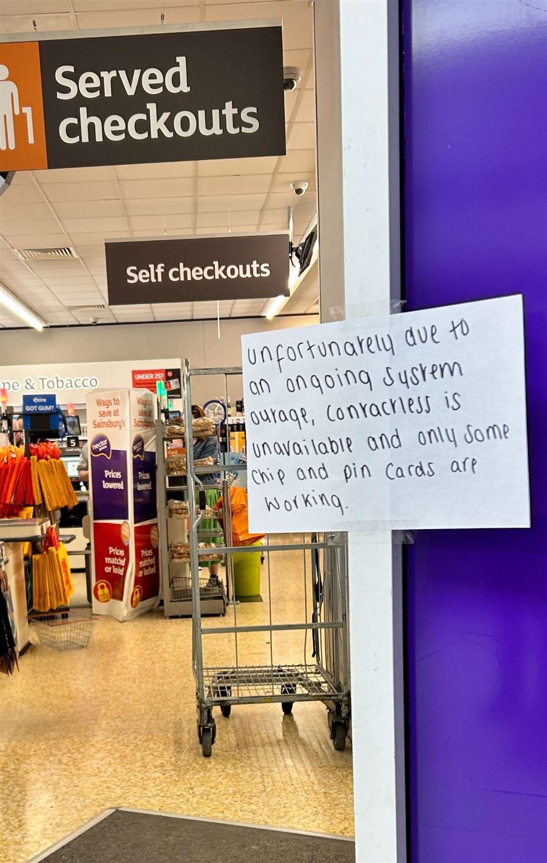 A hand-written notice informing customers of technical issues at a Sainsbury’s store in Huddersfield (Ashley Broadley/PA)