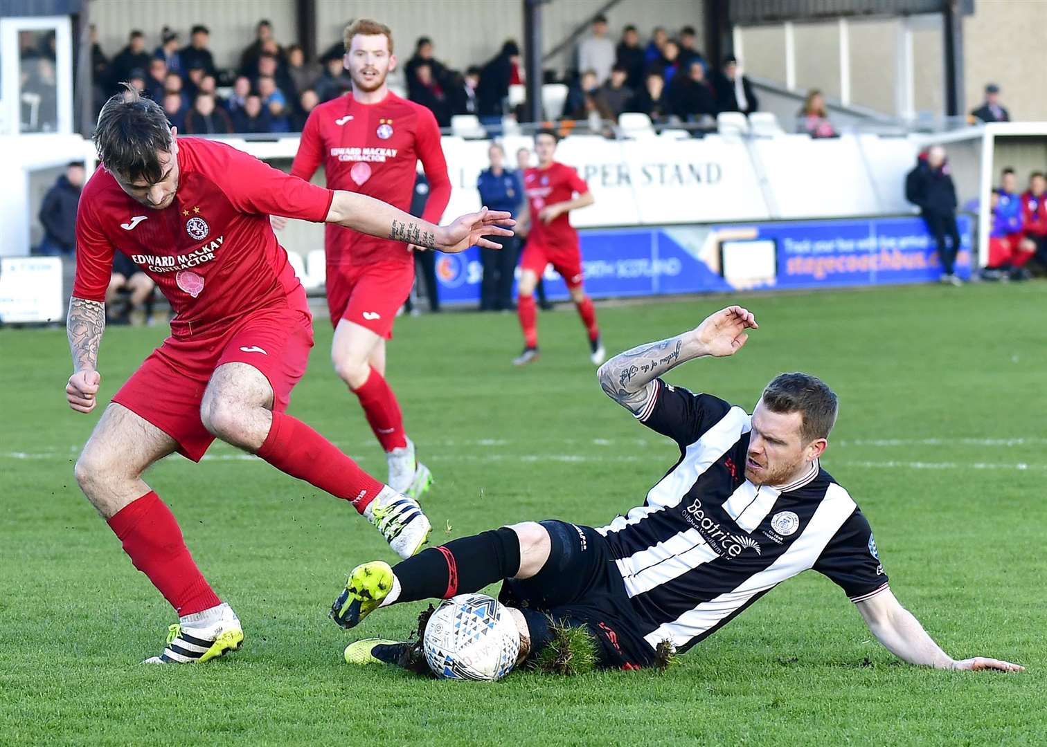 Wick Academy's makeshift right-back Craig Gunn slides in to steal the ball from Brora's Paul Brindle. Picture: Mel Roger