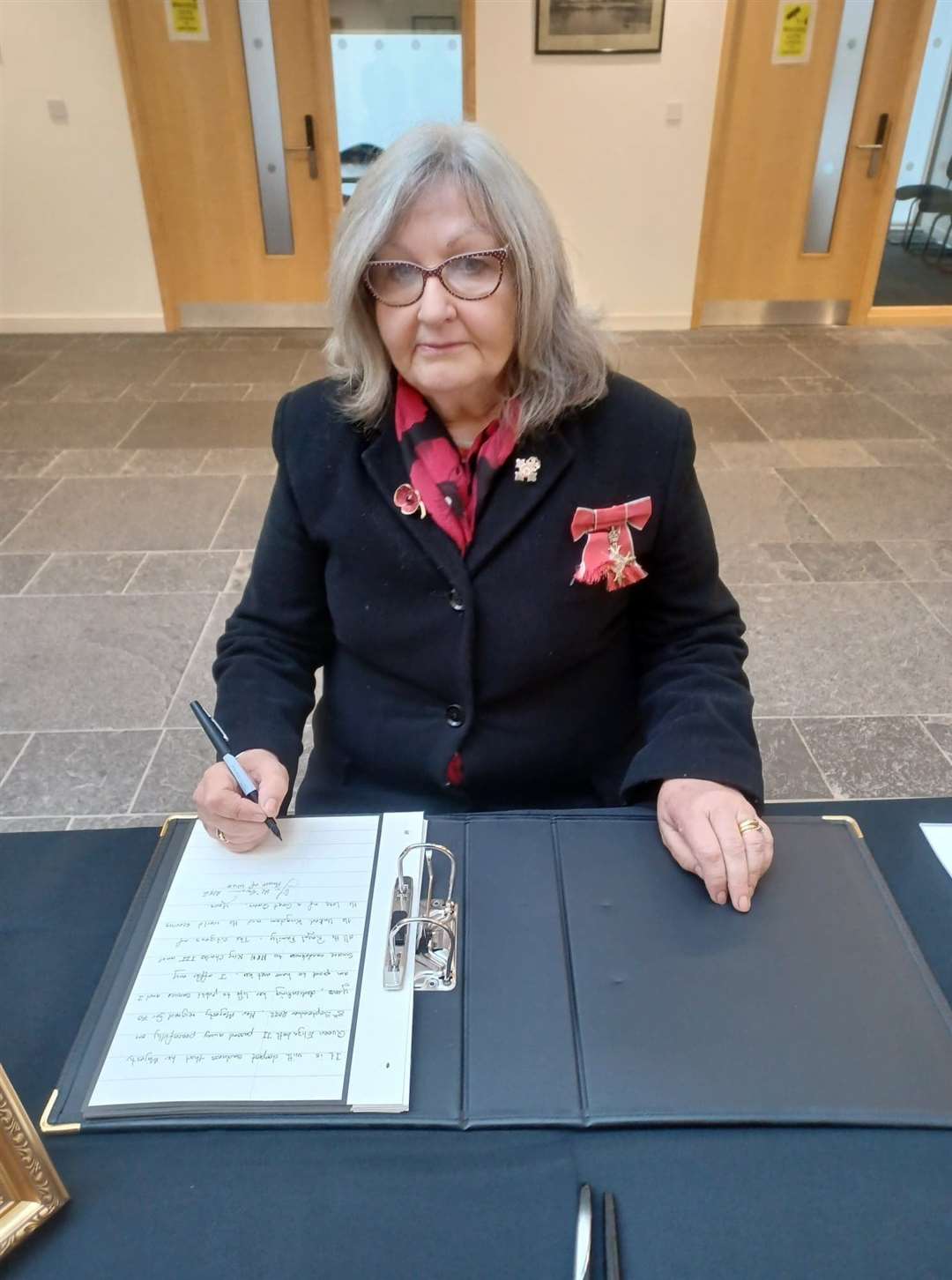 Provost Jan McEwan signing the book of condolence in Caithness House.