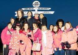The four VIPs are joined by pink-clad fans for the obligatory souvenir photo at the famous John O’Groats signpost.