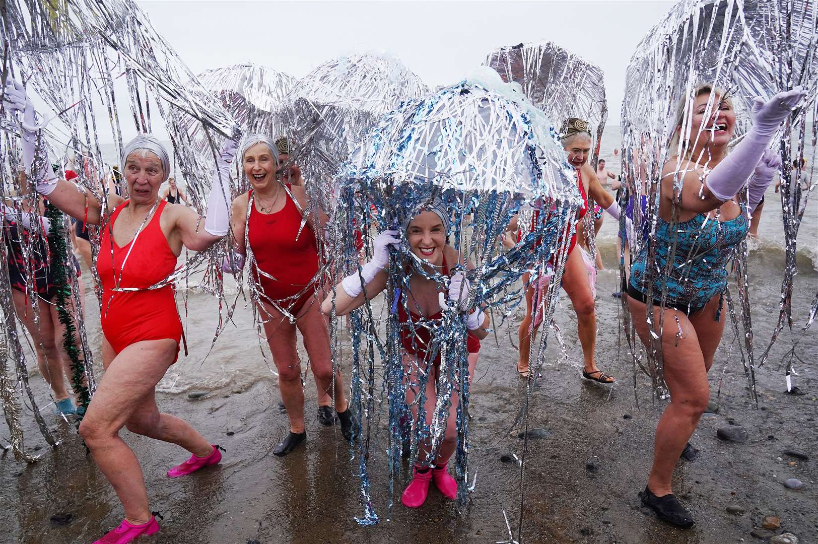 Members of the Bray Beach Bathers leave the water after taking part in the annual New Year’s Day charity swim in Co Wicklow (Brian Lawless/PA)
