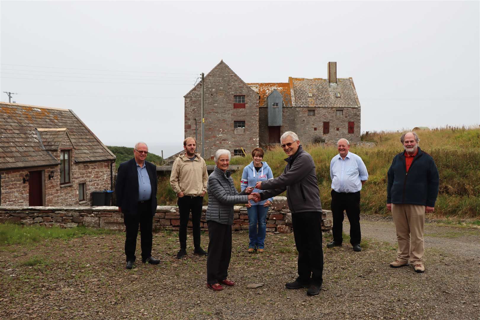 Sina Houston handing the keys to Rognvald Brown, chairman of the John O'Groats Mill Trust, with some of the trust board members looking on – (from left) Ian Leith, Darren Coghill, Fiona Harper, Walter Mowat and Lyall Rennie.