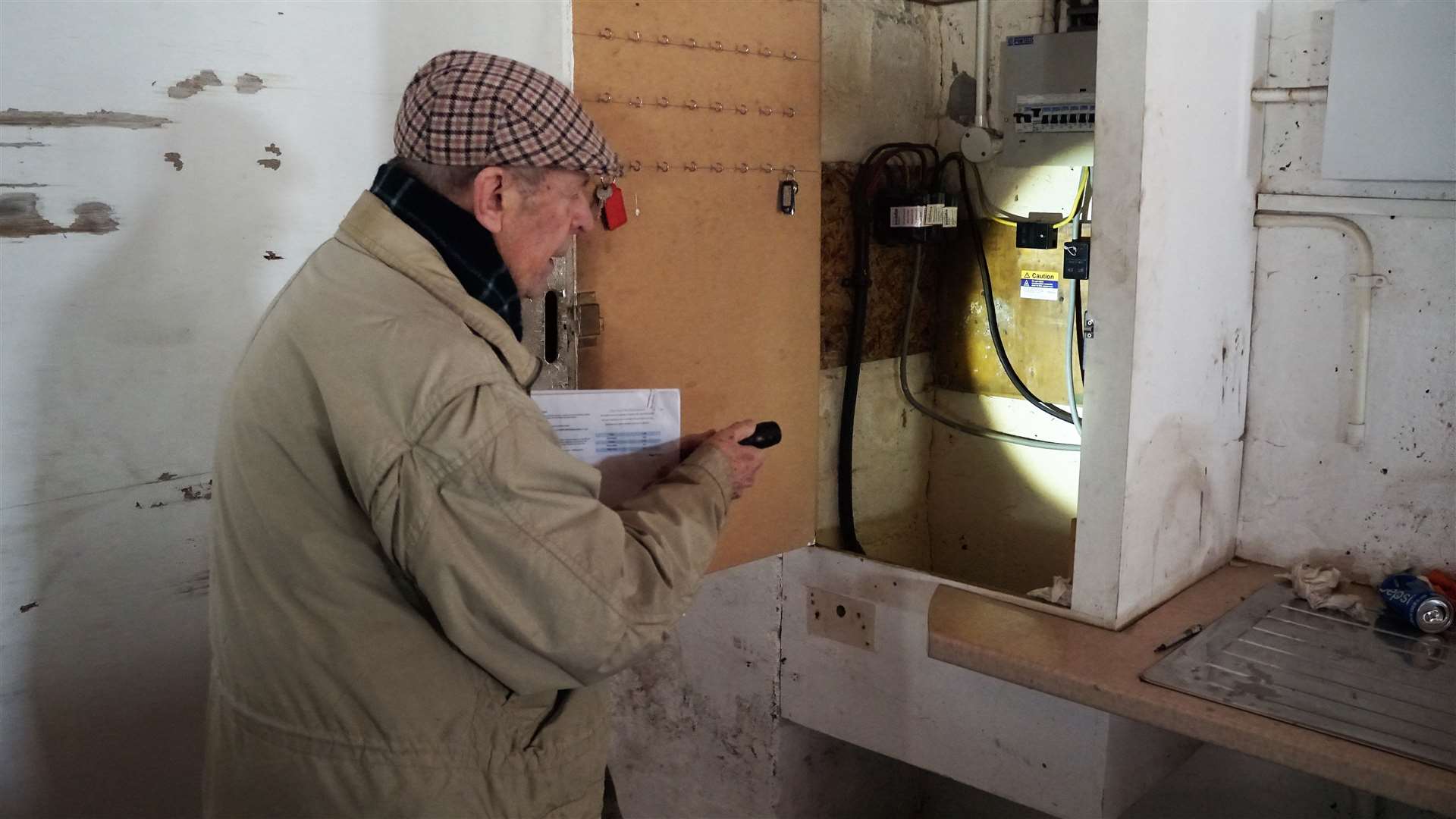 Mr Clark needs to use a torch to look around his garage as the power supply is disconnected. He showed the meter with the reading it is stuck at since being 'de-energised' on February 9. Picture: DGS