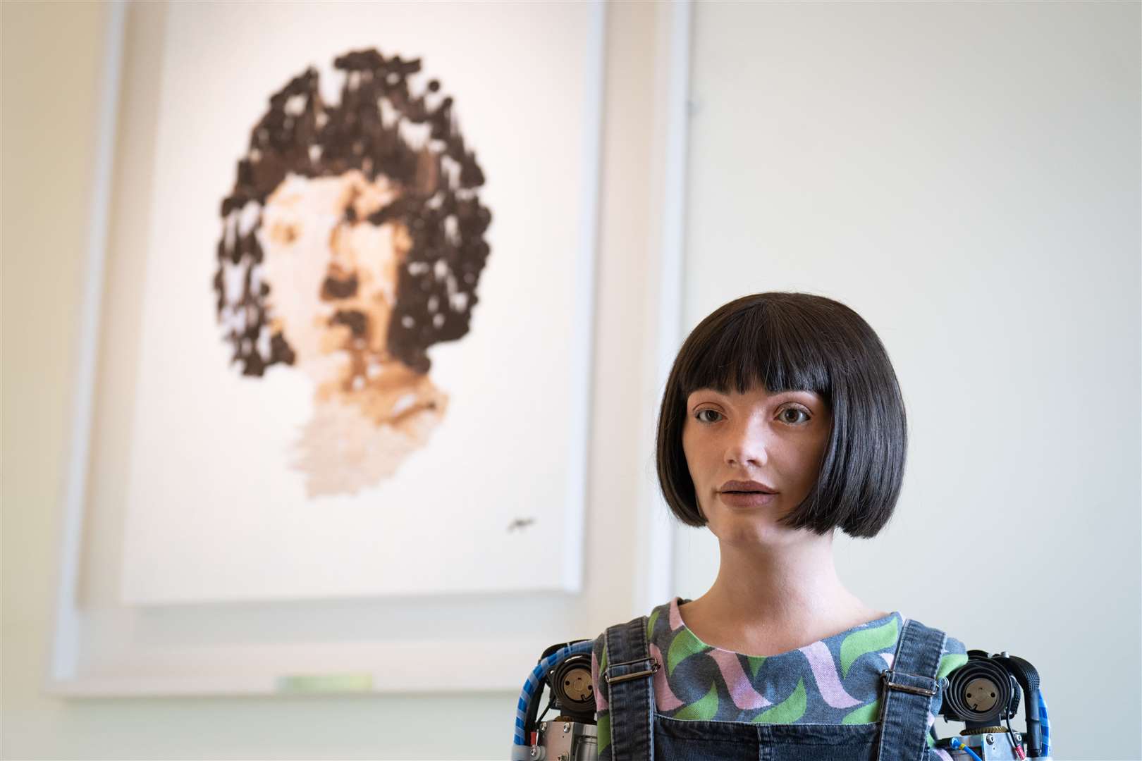 Ai-da the robot near her self portrait in June (PA)