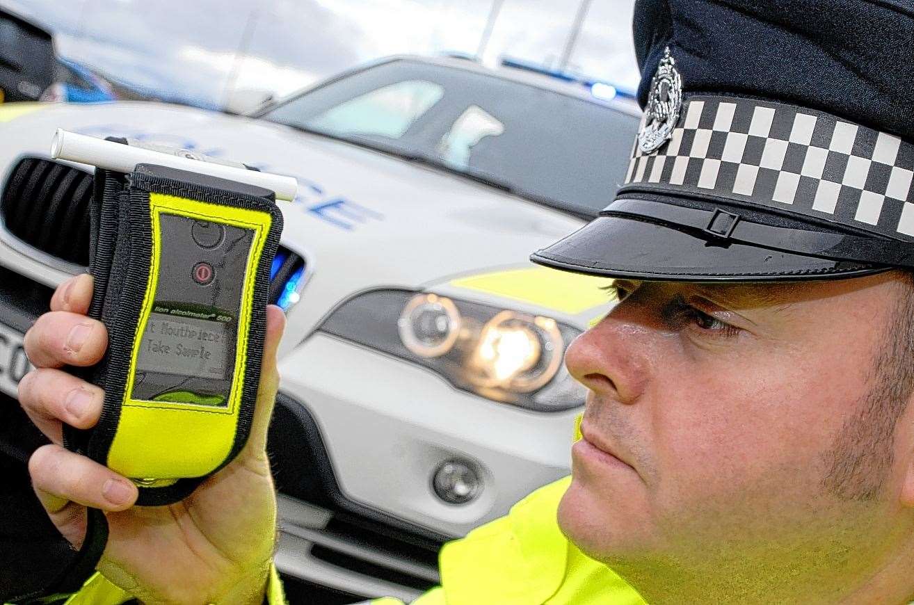 A police officer with a breathalyser.