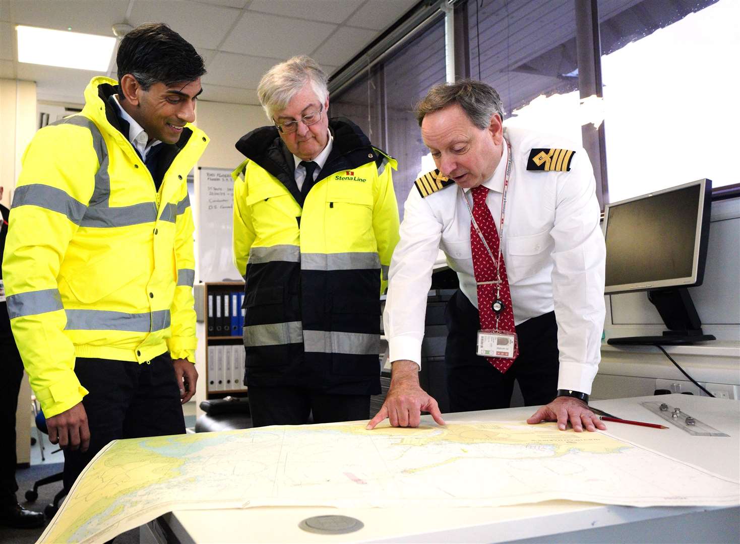(left to right) Prime Minister Rishi Sunak and First Minister of Wales Mark Drakeford with John Goddard harbour master looking at charts during a visit to the Port of Holyhead in Anglesey (Peter Byrne/PA)