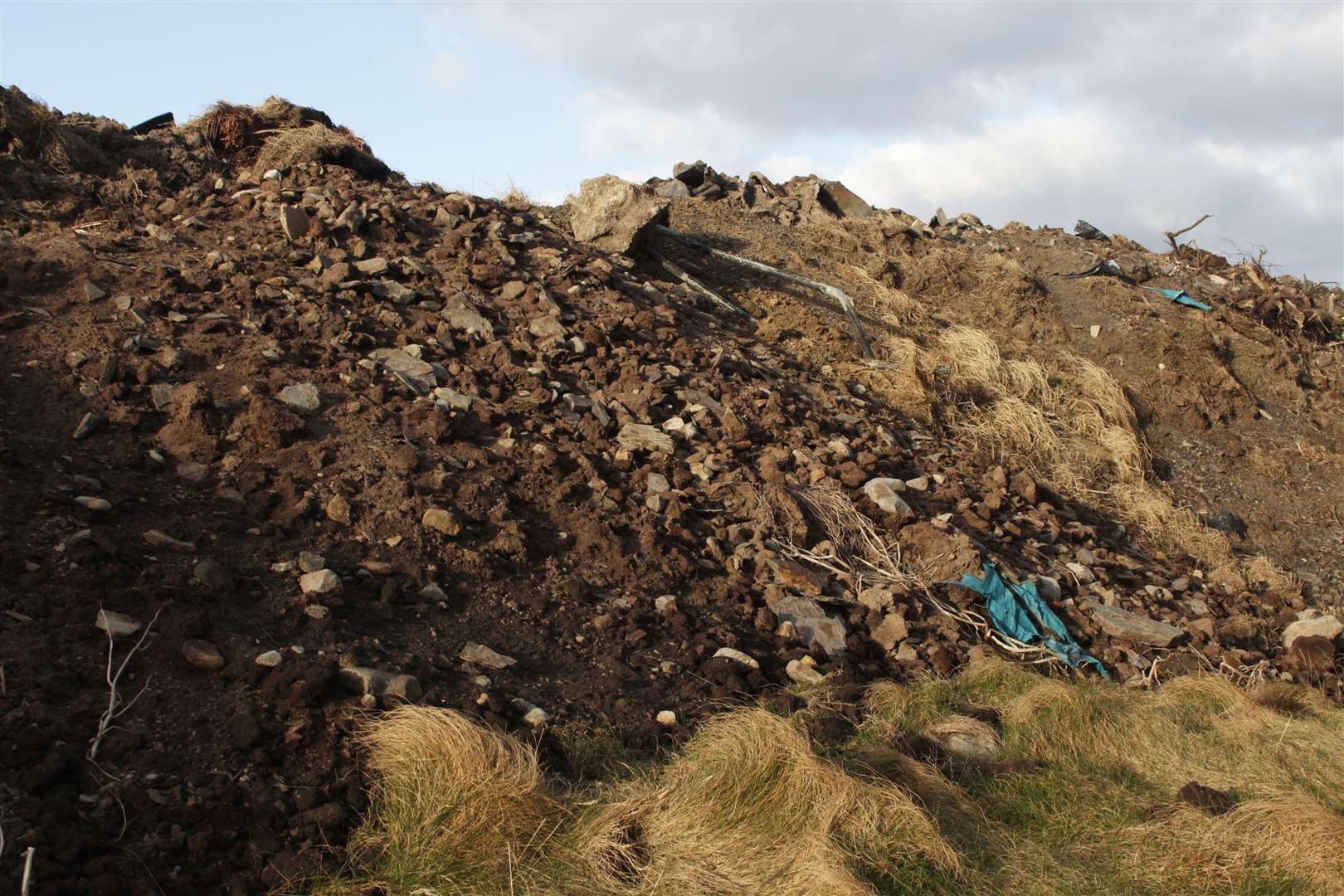 Waste is scattered down a slope just below the South Head footpath.