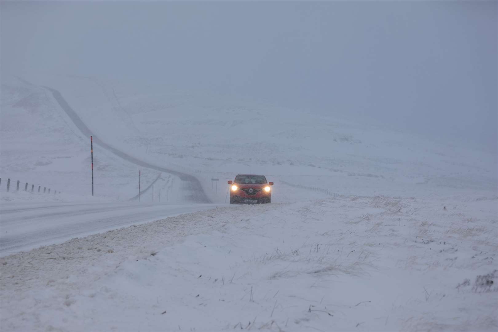 A car makes it way along the A939 after heavy snowfall in the Cairngorms (Paul Campbell/PA)