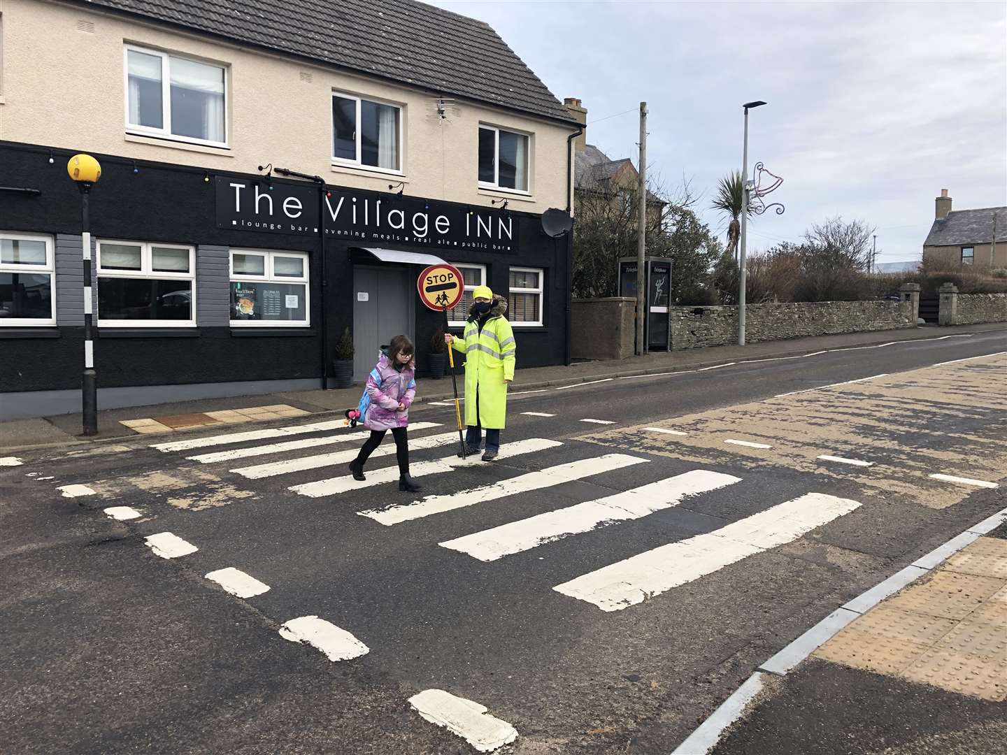 Newly appointed crossing patroller Carrieanne Johnston helping Keiss pupil Katie Polson get to school this morning.