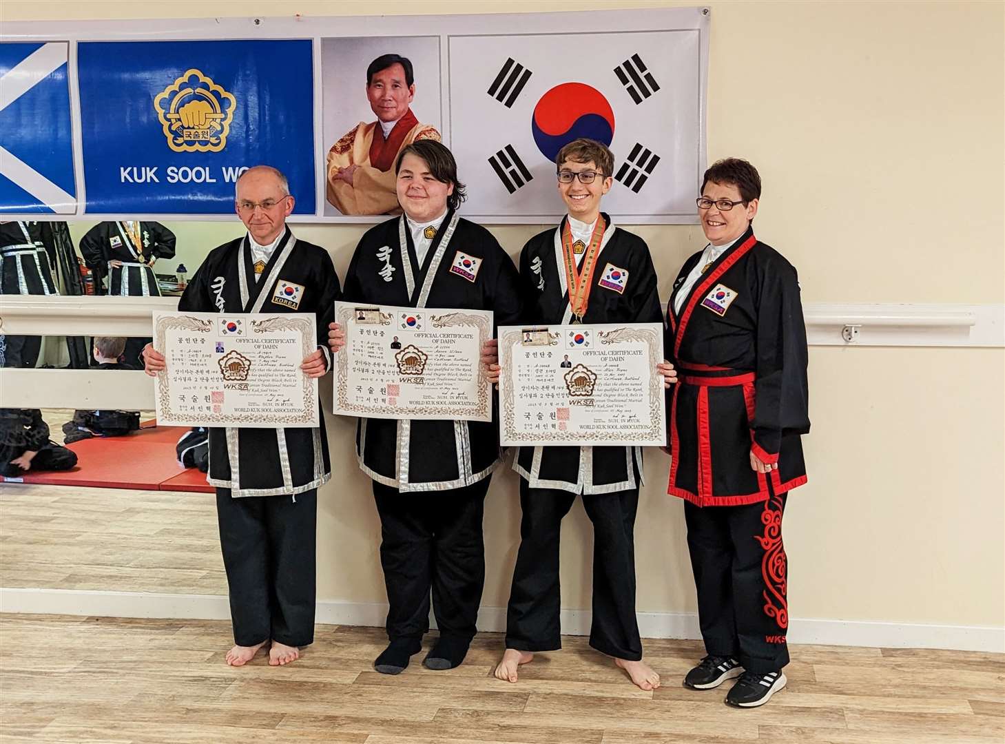 From left: Caithness Kuk Sool Won students Stephen Frame, Aaron Wilson and Alan Frame after their promotions, with instructor Cathy Smith.