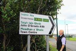 Highland Councillor Wille Mackay inspects the newly erected bilingual sign on the main A 99 at its junction with the road to the airport.
