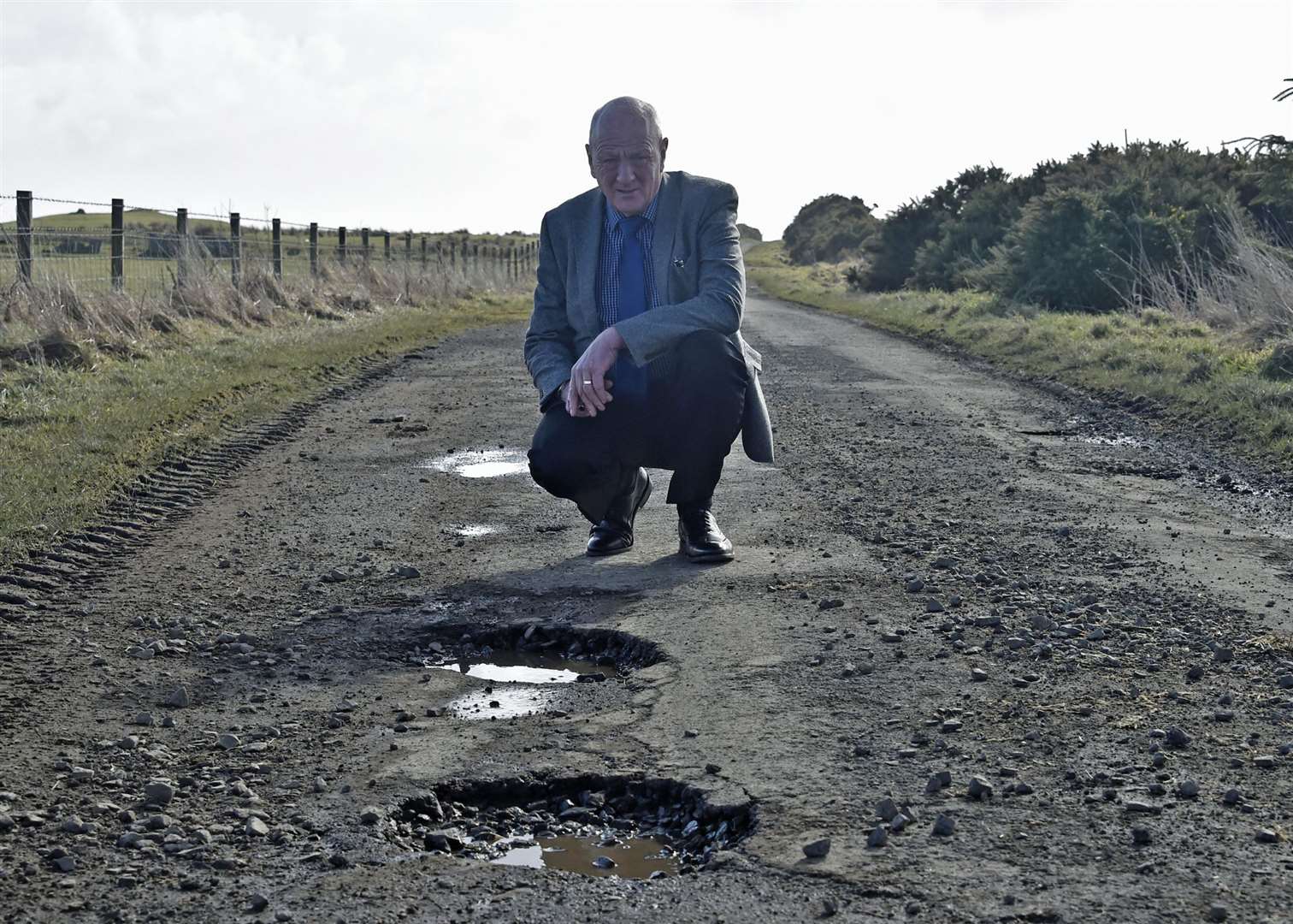 Iain Gregory says state of Caithness roads is "utterly catastrophic" and wants government funding to solve the problem. He is seen here viewing potholes at Tain, near Castletown.