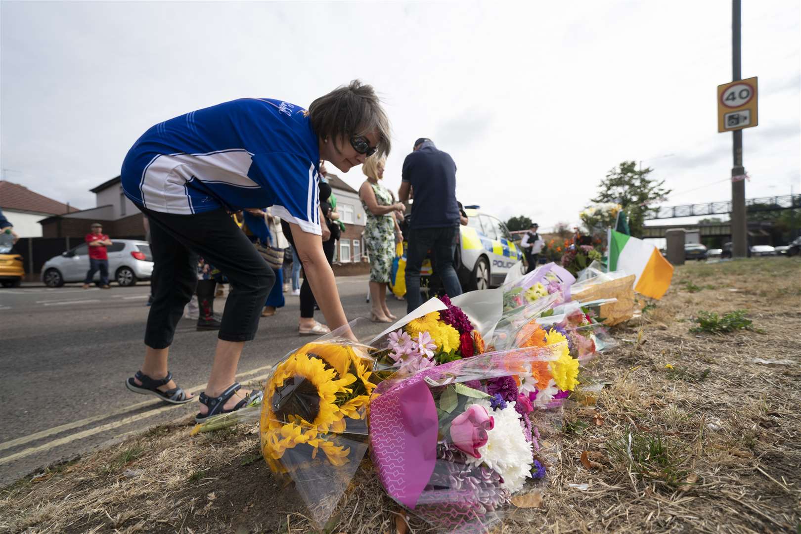A woman lays flowers in memory of Mr O’Halloran (Kirsty O’Connor/PA)