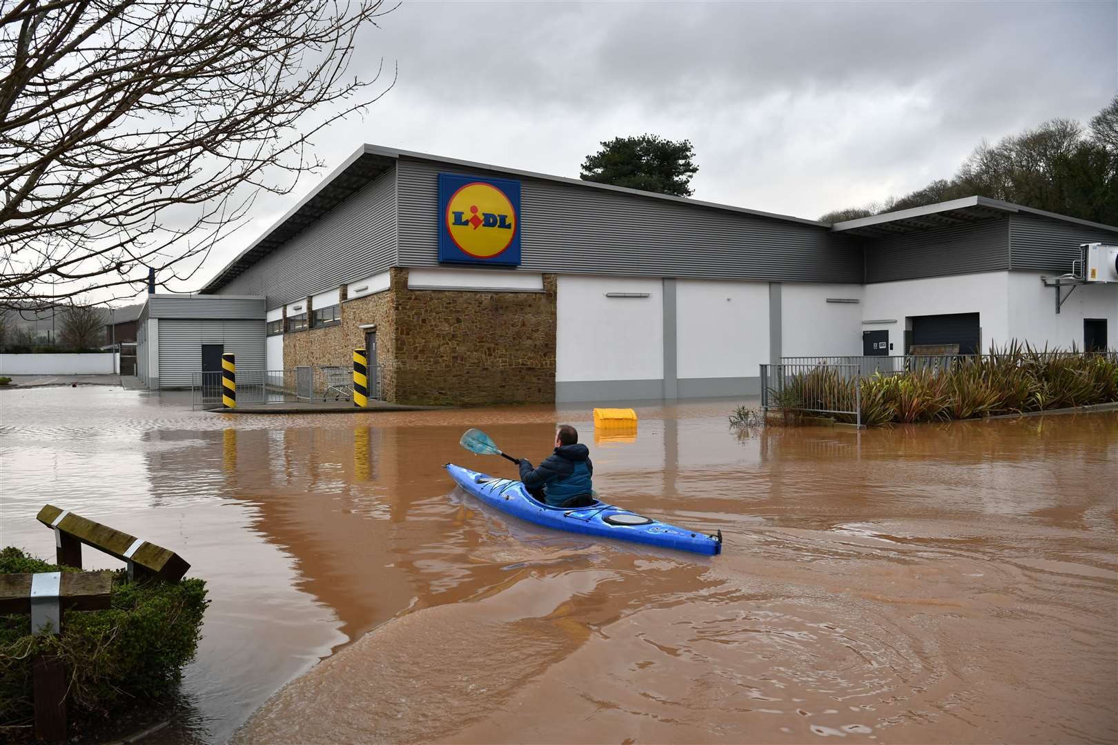 A canoeist makes their way towards Lidl in Monmouth in the aftermath of Storm Dennis in February 2020 (Ben Birchall/PA)