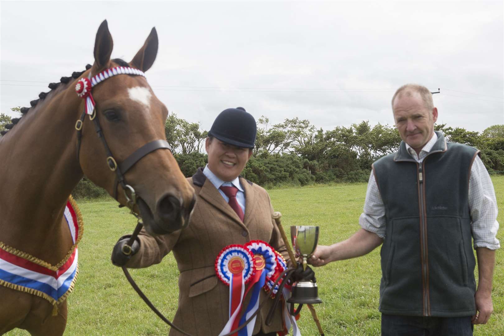 A delighted Kimmy Lai, Dempster Street, Wick, receives the champion of champions trophy from judge, William Macdonald, Tormore, Dunbeath. She won the award with supreme horse champion and light-legged champion, Ashlea's Hollywood Showgirl, a three-year-old by Hollywood. Picture: Robert MacDonald/Northern Studios