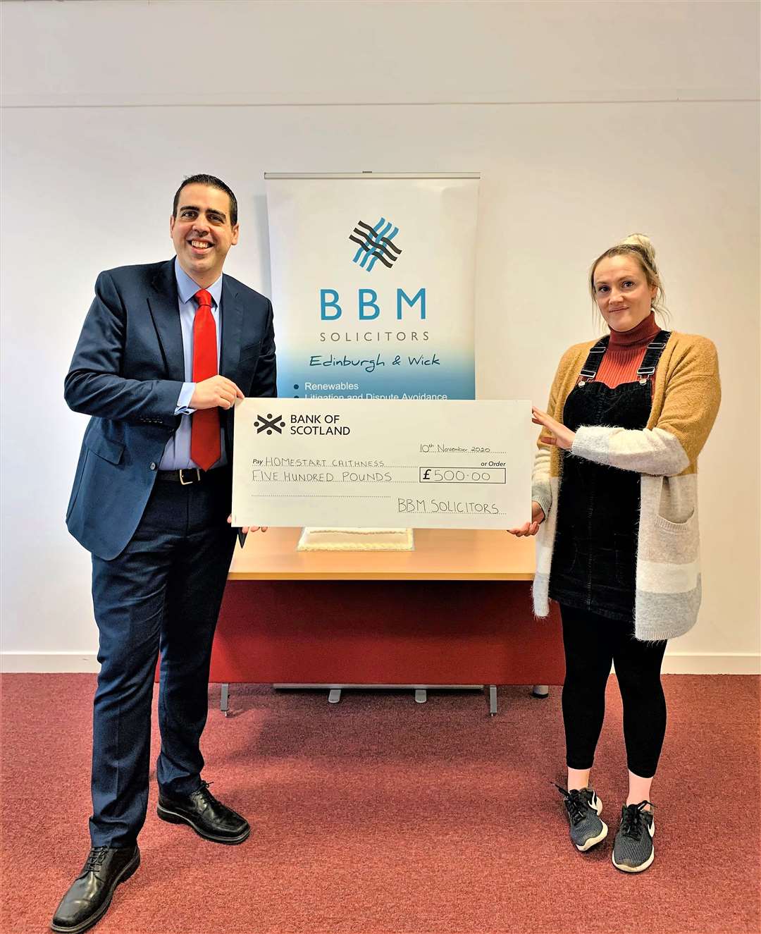 Eric Baijal hands over a £500 charity donation from BBM solicitors to Moira Smith, family services coordinator with Home Start Caithness.