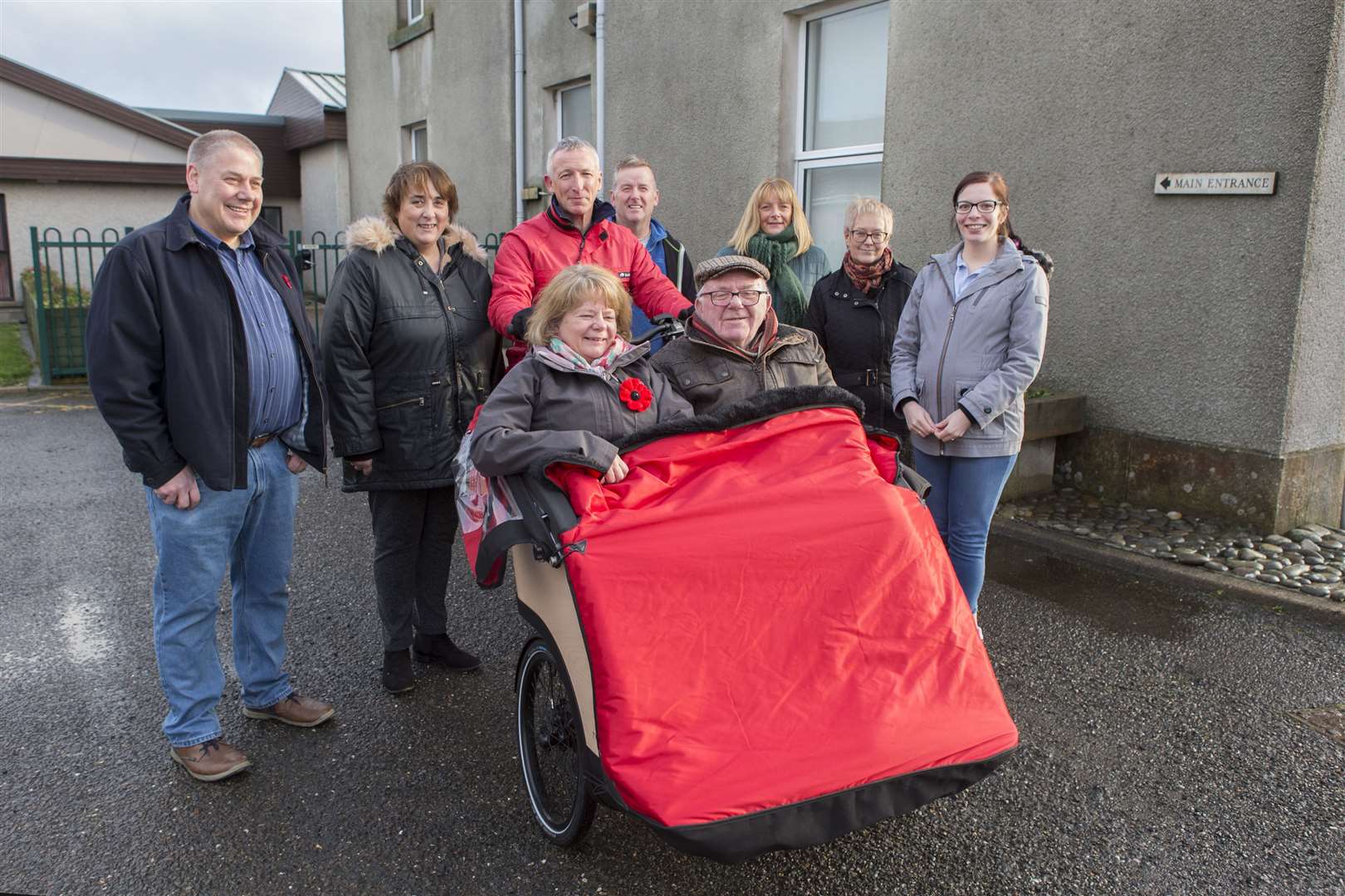The Triotaxi on its maiden journey from Pulteney House with Iain Sutherland in the passenger seat along with his daughter Helen Hill, with George Ewing in charge of the pedals. Among those looking on are representatives of the groups that helped with the project and some of those who provided funding. From left: Mervyn Hill, Iain's son-in-law; Isobel Campbell, Befriending Caithness; Robert Cormack, Wick Wheelers; Joanna Coghill, Royal Burgh of Wick Community Council; Yvonne Hendry, Caithness Voluntary Group; and Kayleigh Sinclair (George's daughter), Befriending Caithness. Picture: Robert MacDonald / Northern Studios
