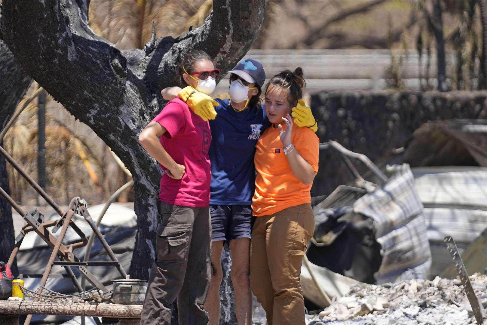 Women hug after digging through the rubble of a home destroyed by the wildfires in Lahaina (Rick Bowmer/AP)