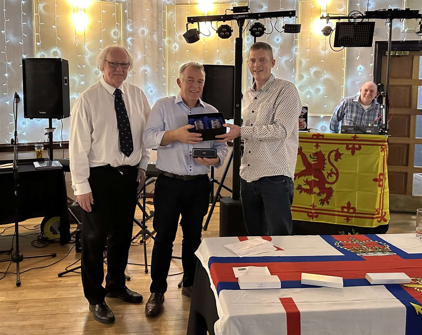 Lifeboat volunteer Gordon Morrison receiving his award from coxswain Allan Lipp, with Murray Lamont, chairman of the Wick lifeboat management committee, looking on.