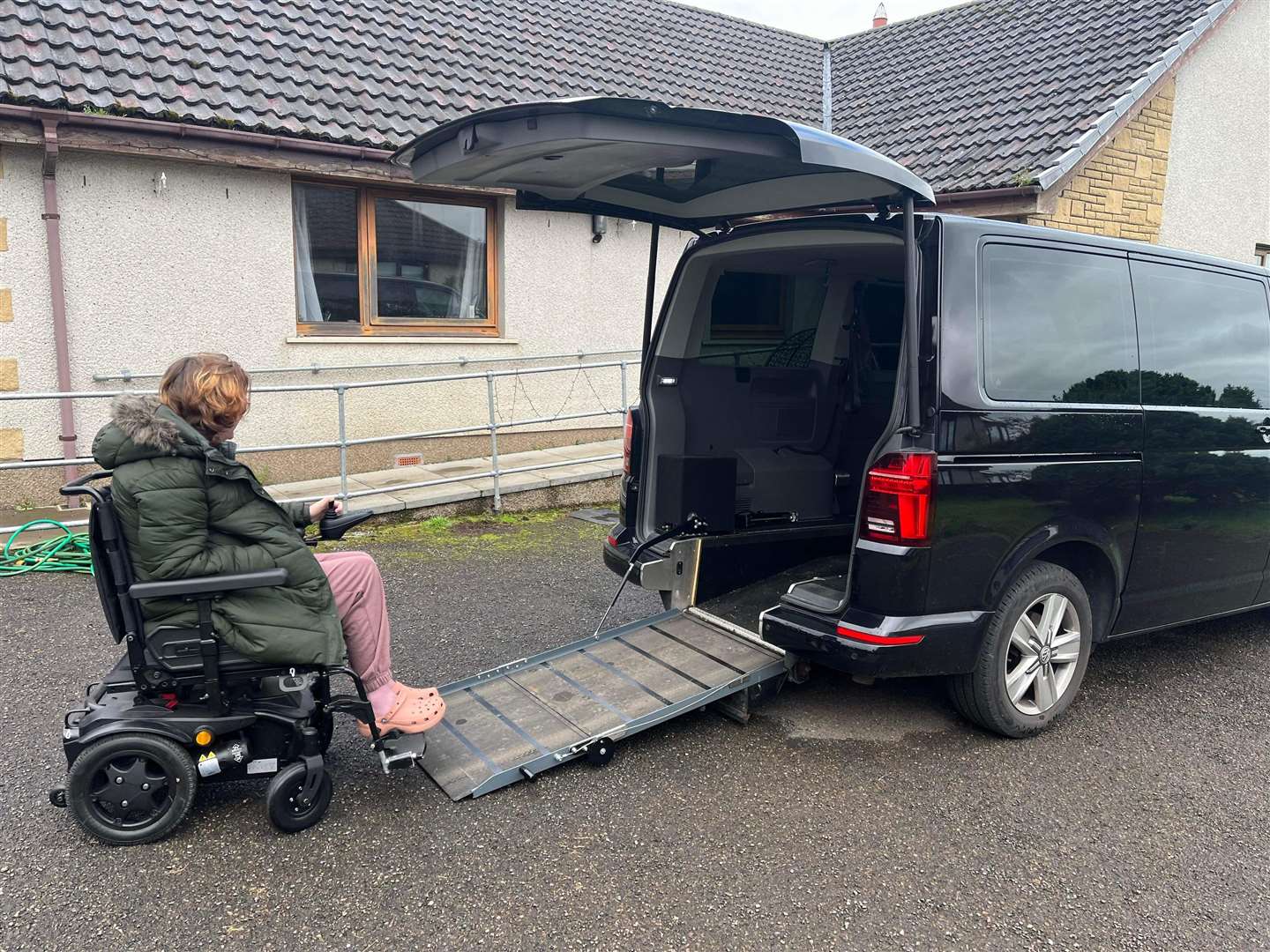 Miss Murphy going up the ramp of her wheelchair accessible vehicle. She blames potholes for causing damage to the ramp mechanism.