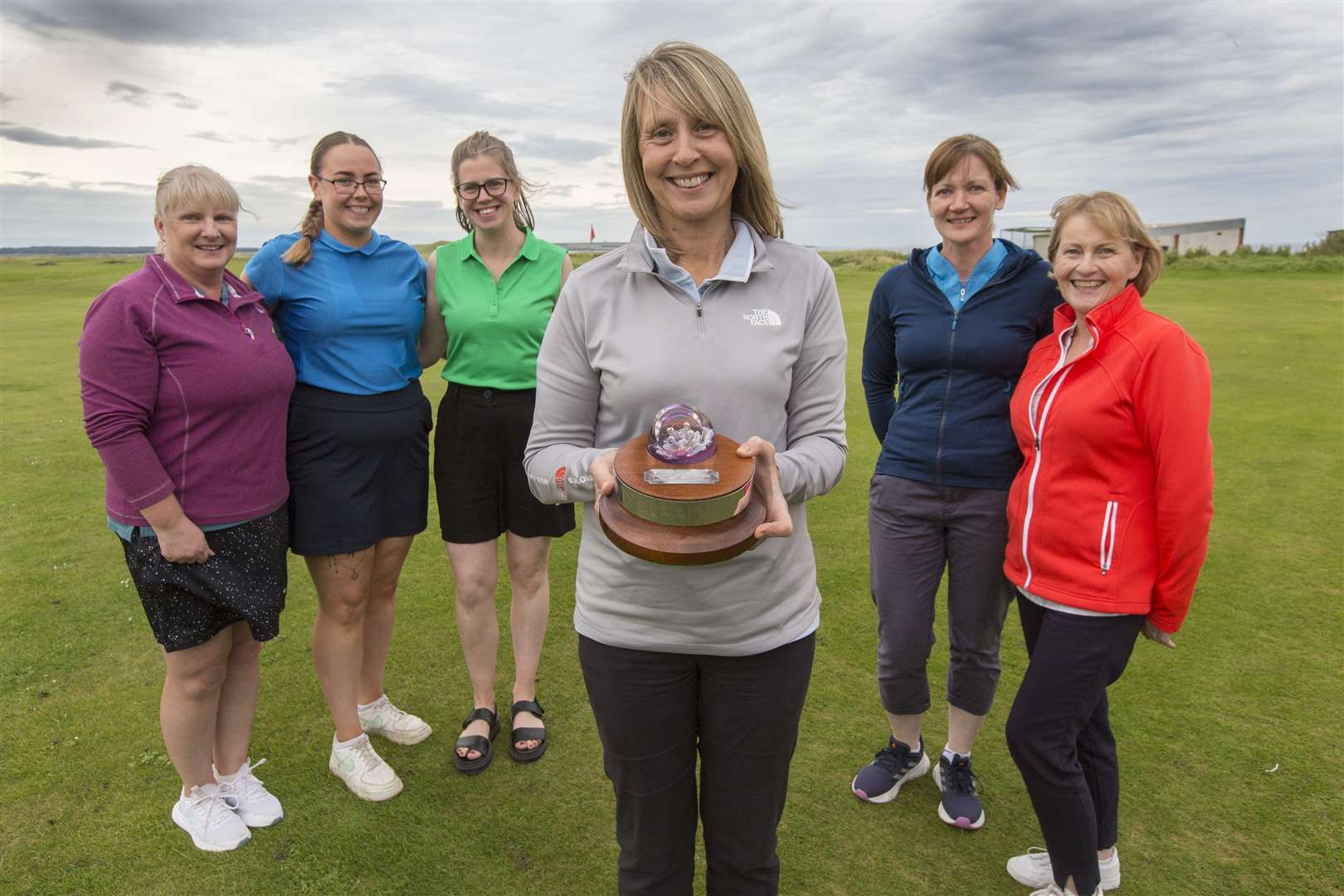 Reay's Pam Bain displays the trophy while some of the Reay ladies who took part look on (from left) Pauline Craig, Sarah Meiklejohn, Rebecca Munro, Heather Campbell and Alison Ross. Picture: Robert MacDonald/Northern Studios