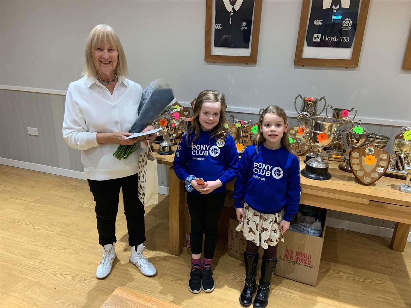 Pauline Coghill received her gifts for long-service from the two youngest members of the club, Rachel MacGregor (centre) and Tessa Simpson.