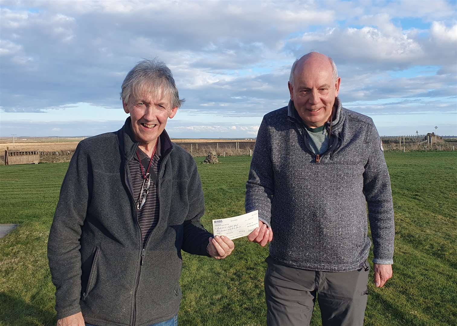 Andy Nicolson (left) of Britannia Bowling Club presents a cheque for £430 to Neil Morrison, chairman of the Caithness Parkinson’s Support Group.
