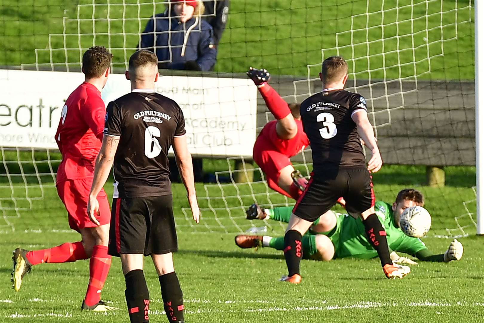 Wick Academy goalkeeper Sean McCarthy dives to save a header from Brora Rangers' Tom Kelly. Picture: Mel Roger
