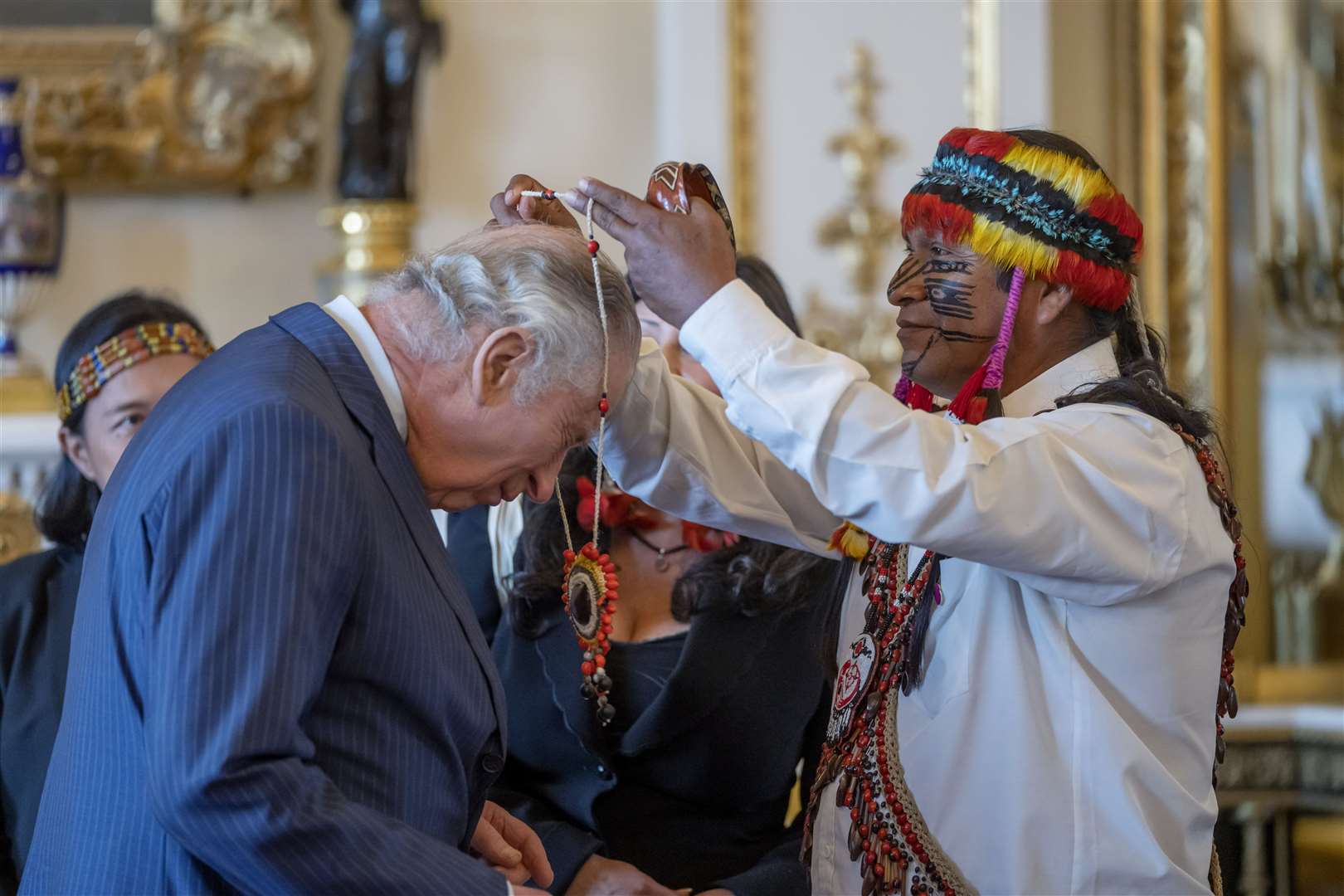 Amazon Indigenous leader Domingo Peas presents a gift to the King during a reception (Kin Cheung/PA)