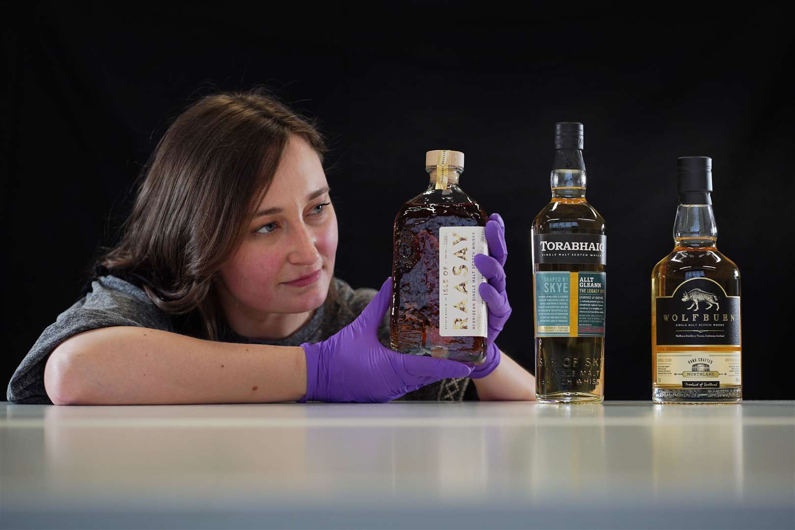 Doctoral researcher Laura Scobie with bottles of whisky, including one from Wolfburn, acquired by National Museums Scotland. Picture: Stewart Attwood