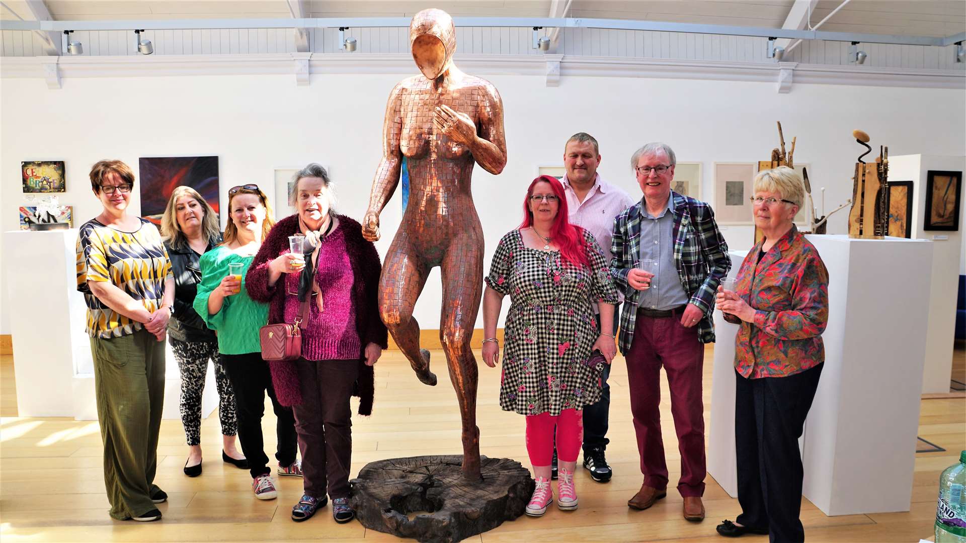 Some of the artists at the show's opening on Friday afternoon alongside Keith Coghill's sculpture. Picture: DGS