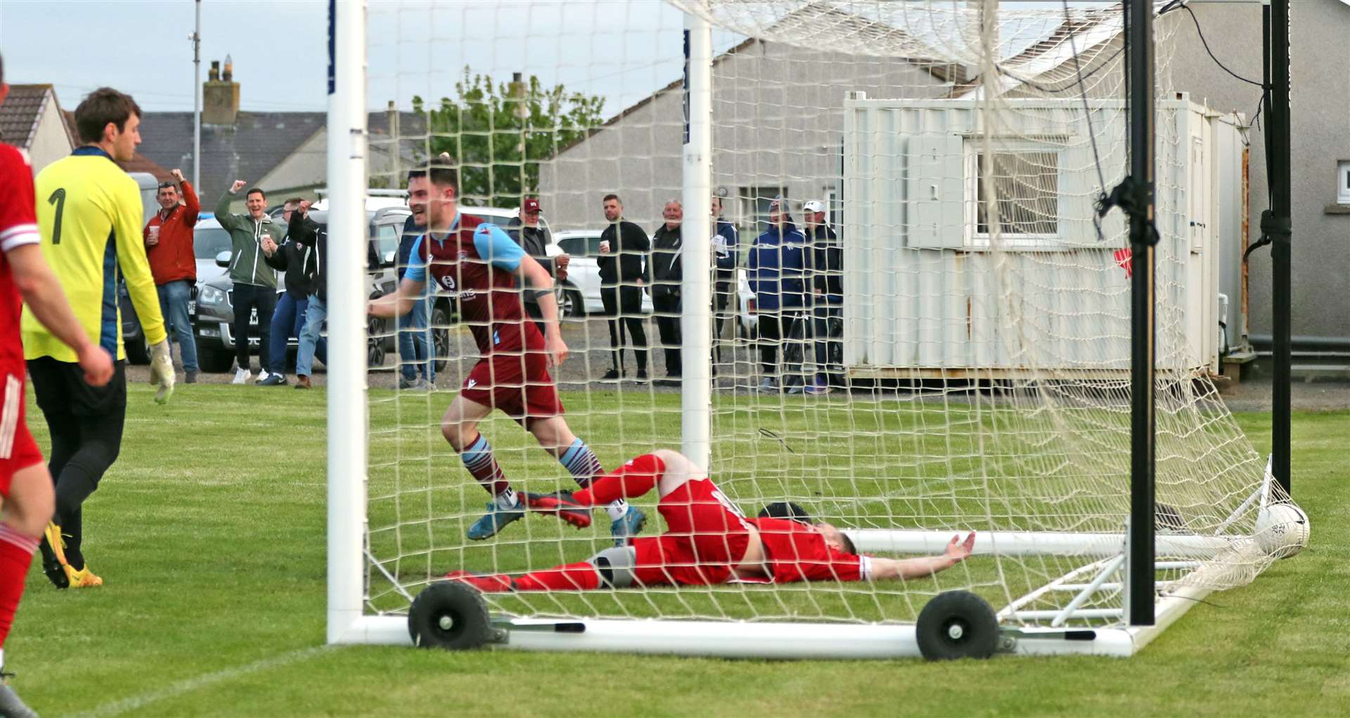 Conor Cormack celebrates after putting Pentland United in front, with Wick Groats' Sean Stewart sprawled on the ground. Picture: James Gunn
