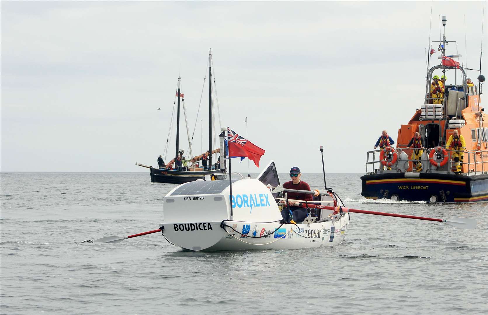 Mhairi at the oars with the Isabella Fortuna and Wick lifeboat beyond. Picture: Alan Hendry